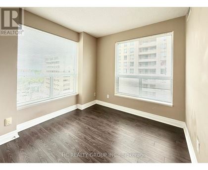 A room with a large window and a view of a building across the street.