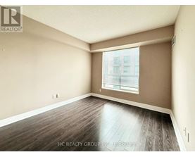 A room with wooden flooring and a window with blinds.