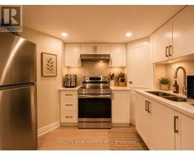 A modern kitchen with white cabinets and stainless steel appliances.