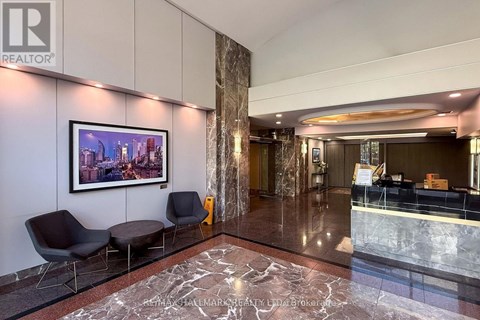 A living room with a grey sofa and a framed picture on the wall.