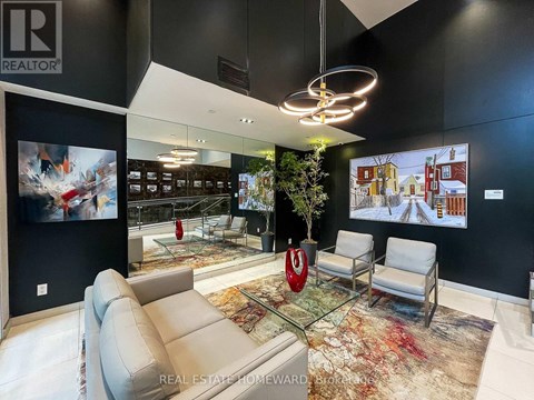 A modern living room with a glass table and a large painting on the wall.