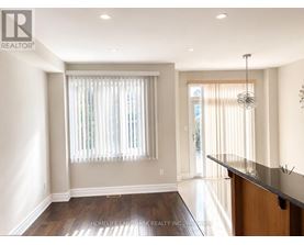 A well-lit, spacious room with a wooden floor and a bar area.