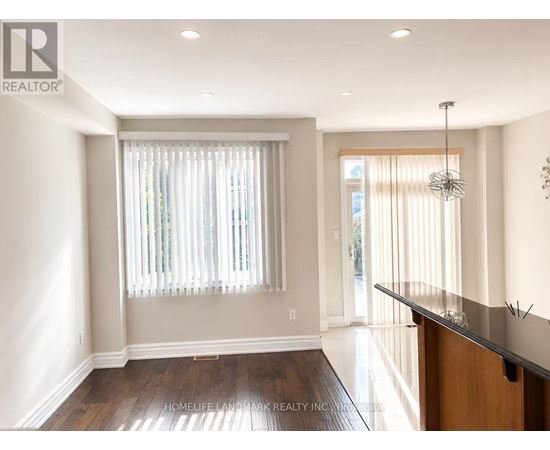 A well-lit, spacious room with a wooden floor and a bar area.
