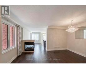 A spacious living room with a fireplace and a chandelier.