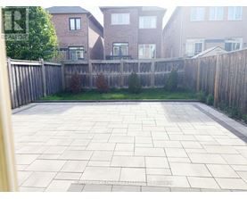 A backyard with a paved patio and a wooden fence.