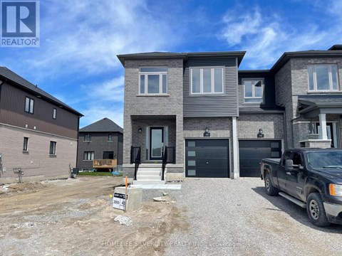 A real estate sign is displayed in front of a newly constructed house.