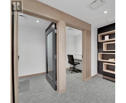 A room with a black chair and a wooden door.