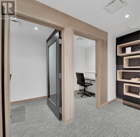 A room with a black chair and a wooden door.