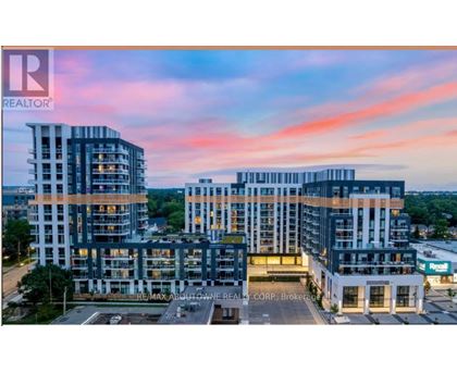 A modern multi-story building complex with the RE/MAX Aboutown Realty Corp. Brokerage sign in front.