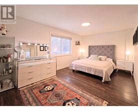 A bedroom with a bed, dresser, and rug.