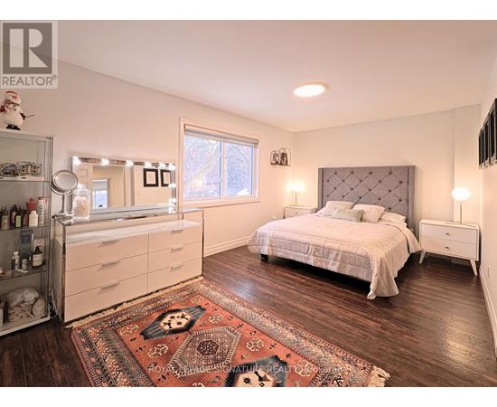 A bedroom with a bed, dresser, and rug.