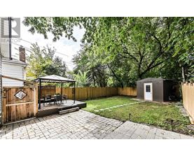 A backyard with a patio and a small building.