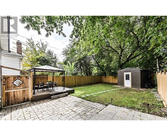 A backyard with a patio and a small building.