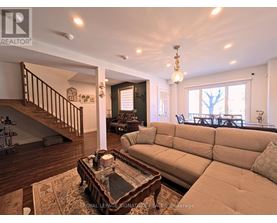 A living room with a couch, coffee table, and staircase.