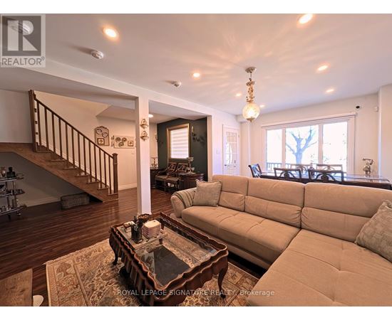 A living room with a couch, coffee table, and staircase.