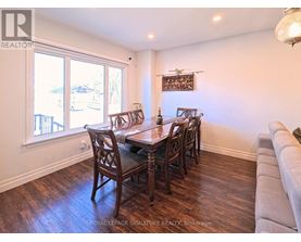 A dining room with a wooden table and chairs.