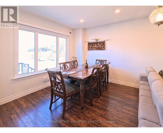 A dining room with a wooden table and chairs.