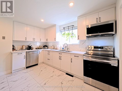 A kitchen with white cabinets and appliances.