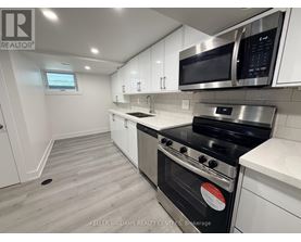 A modern kitchen with white cabinets and stainless steel appliances.