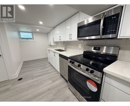 A modern kitchen with white cabinets and stainless steel appliances.