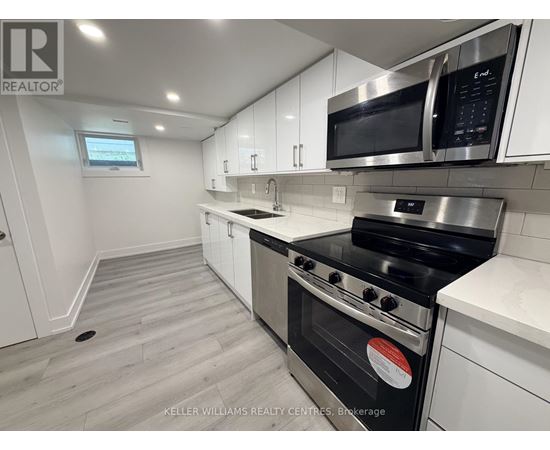 A modern kitchen with white cabinets and stainless steel appliances.
