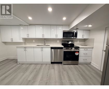A modern kitchen with white cabinets and stainless steel appliances.
