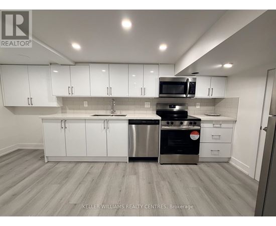 A modern kitchen with white cabinets and stainless steel appliances.