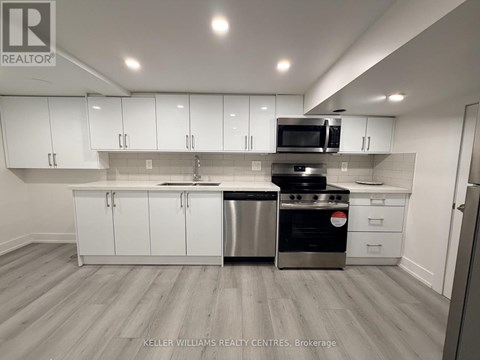 A modern kitchen with white cabinets and stainless steel appliances.