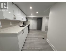 A kitchen with white cabinets and a tiled backsplash.