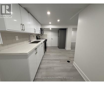 A kitchen with white cabinets and a tiled backsplash.