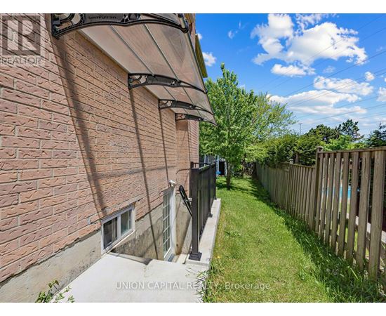A brick building with a wooden fence in the yard.