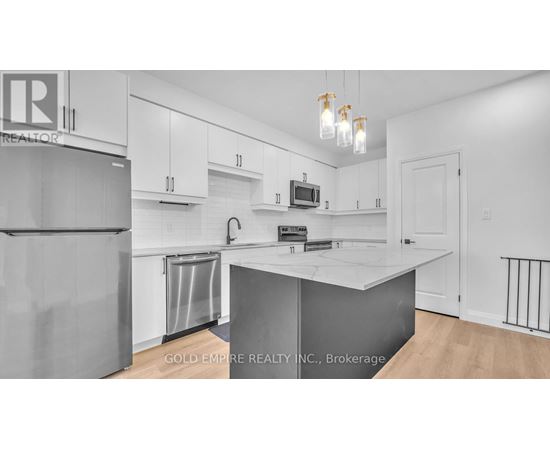 A kitchen with white cabinets and a white island.