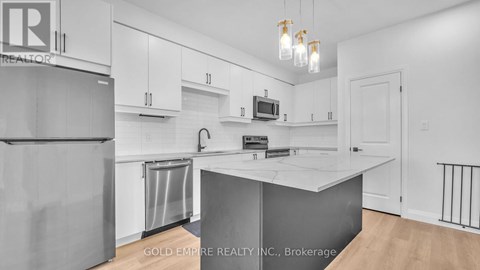 A kitchen with white cabinets and a white island.