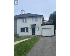 A house with a grey roof and a white garage door.