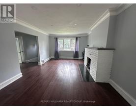 A room with a fireplace and wood flooring.