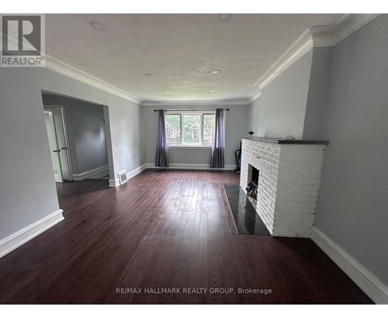 A room with a fireplace and wood flooring.