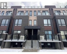 A building with a black door and windows with a sign that says REALTOR.