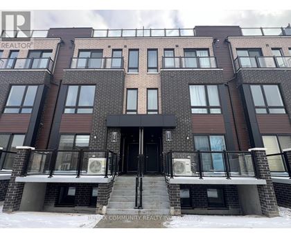 A building with a black door and windows with a sign that says REALTOR.
