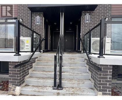 A set of stairs leading to a black door with a glass window above it.