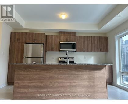 A kitchen with brown cabinets and a wooden counter.