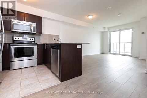 A modern kitchen with dark brown cabinets and stainless steel appliances.