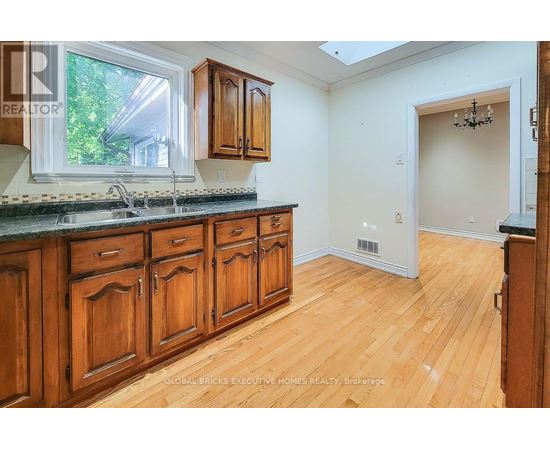 A kitchen with wooden cabinets and a window.