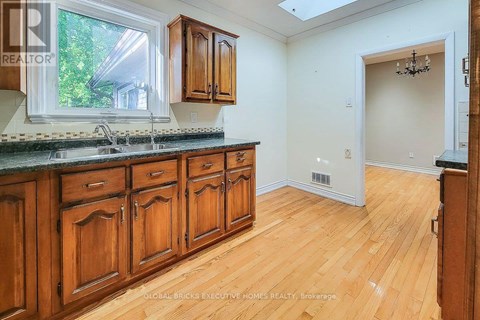 A kitchen with wooden cabinets and a window.