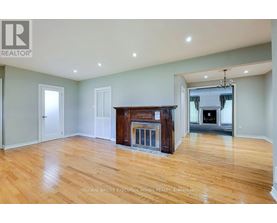 A spacious living room with a fireplace and hardwood floors.