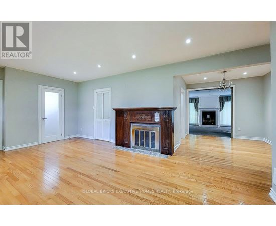 A spacious living room with a fireplace and hardwood floors.