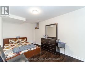 A bedroom with a bed, dresser, and mirror.