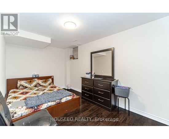 A bedroom with a bed, dresser, and mirror.