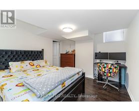 A bedroom with a bed, a desk, and a chair.