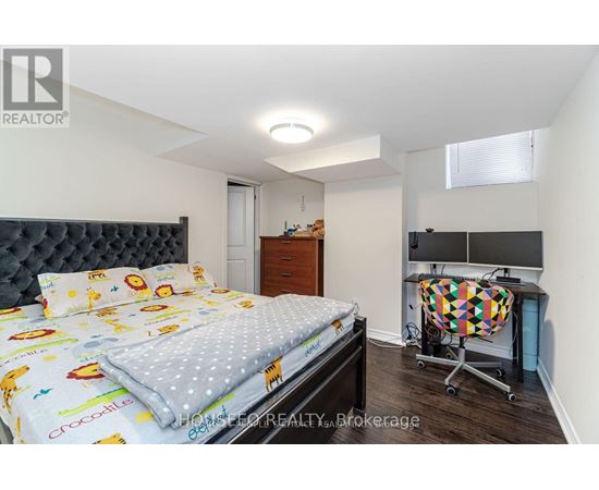 A bedroom with a bed, a desk, and a chair.