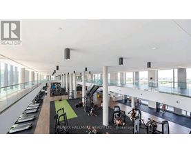 A gym with a row of treadmills on the left and a row of exercise bikes on the right.